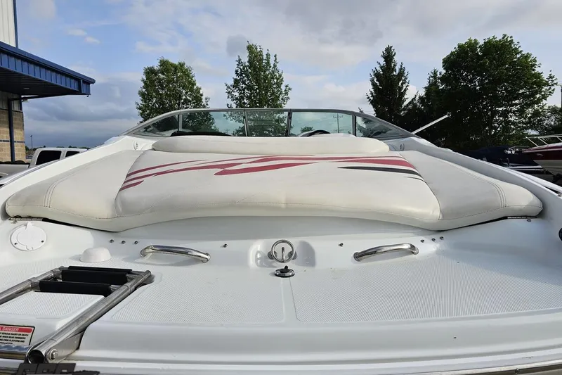 Slide: The Image of 2004 Baja 275 boat with cushioned seating, docked outdoors under a cloudy sky. - 31
