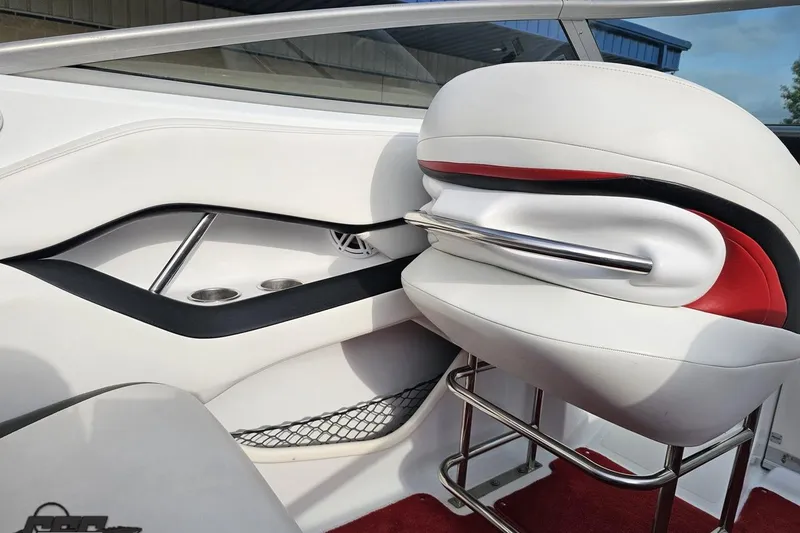 Slide: The Image of Interior of a 2004 Baja 275 boat featuring white and red seating with cup holders. - 49
