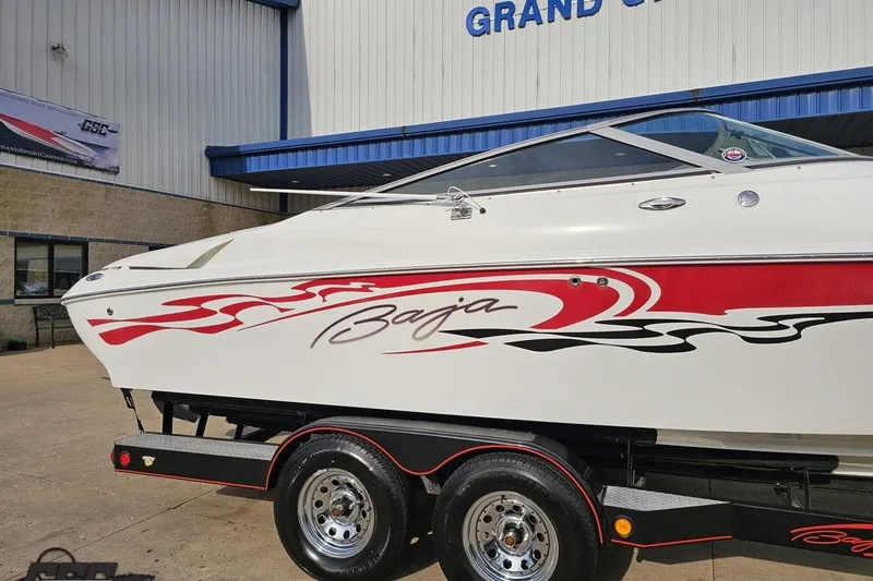 Slide: The Image of 2004 Baja 275 boat with red graphics on trailer outside dealership. - 5