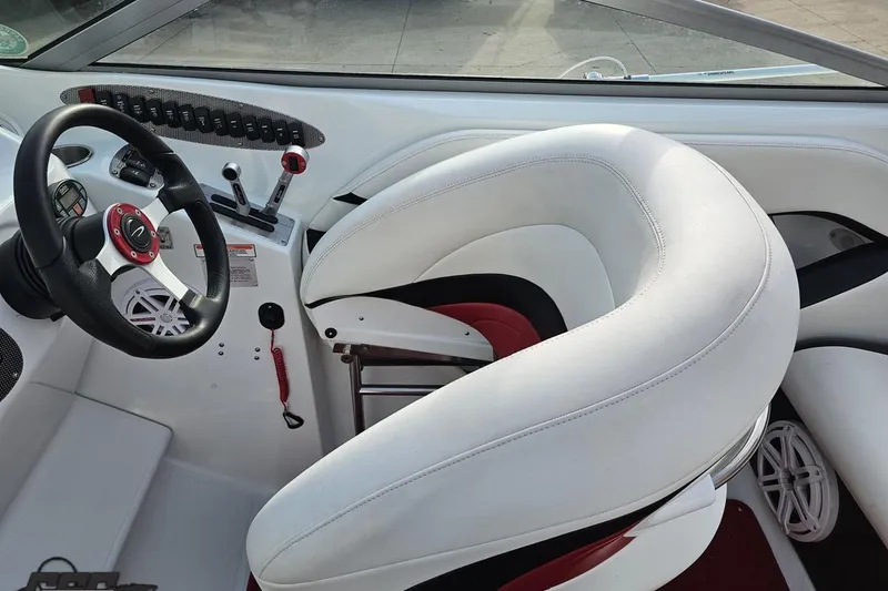 Slide: The Image of Interior of a 2004 Baja 275 boat featuring steering wheel and white seating. - 54