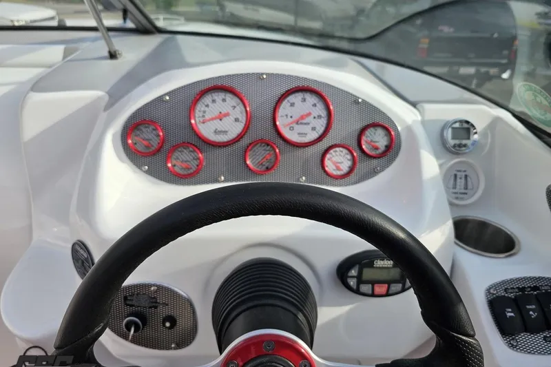 Slide: The Image of Dashboard of a 2004 Baja 275 boat with red-accented gauges and steering wheel. - 56