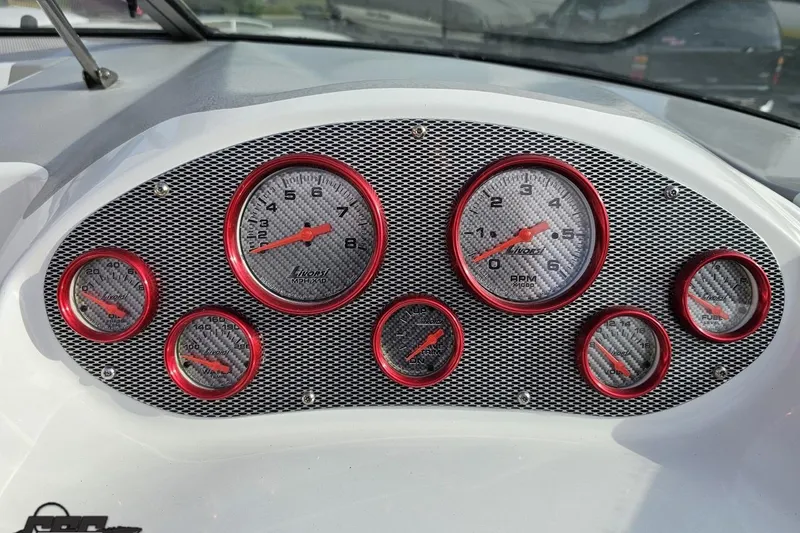 Slide: The Image of Dashboard of a 2004 Baja 275 boat with red-rimmed gauges. - 57