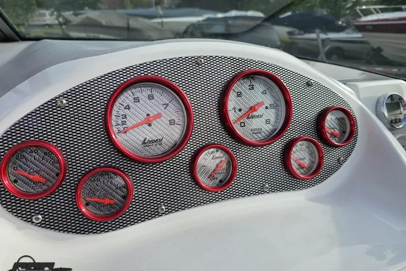 Slide: The Image of Dashboard of a 2004 Baja 275 boat with red-rimmed gauges. - 58