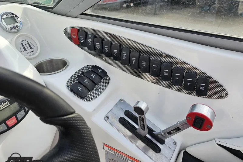 Slide: The Image of Control panel of a 2004 Baja 275 boat with switches and levers. - 59