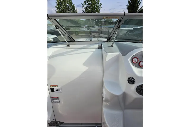 Slide: The Image of 2004 Baja 275 boat dashboard with windshield and gauges, parked outdoors. - 61