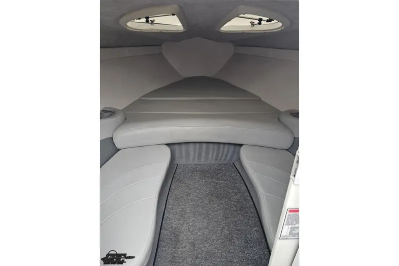 Slide: The Image of 2004 Baja 275 boat interior cabin with gray seating and carpet flooring. - 67