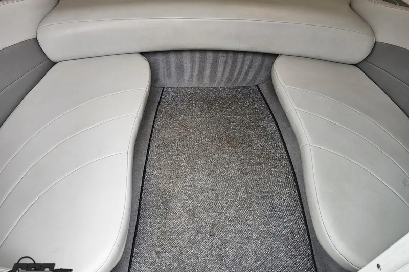 Slide: The Image of 2004 Baja 275 boat interior with gray carpet and white cushioned seating. - 69