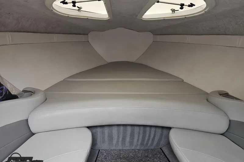 Slide: The Image of Interior cabin of a 2004 Baja 275 boat with cushioned seating and overhead hatch. - 70