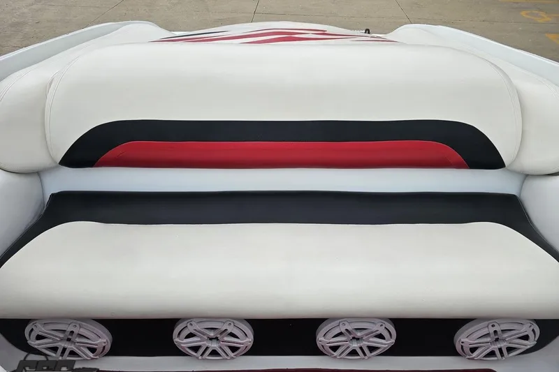 Slide: The Image of 2004 Baja 275 boat interior with white, black, and red seating and speaker system. - 83