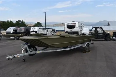Slide: The Image of 2025 Lowe Roughneck 1860 Rambler boat on trailer, parked outdoors with RVs in background. - 2