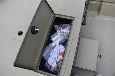 Slide: The Image of Storage compartment on 2025 Lowe Roughneck 1860 Rambler boat, containing various items. - 9