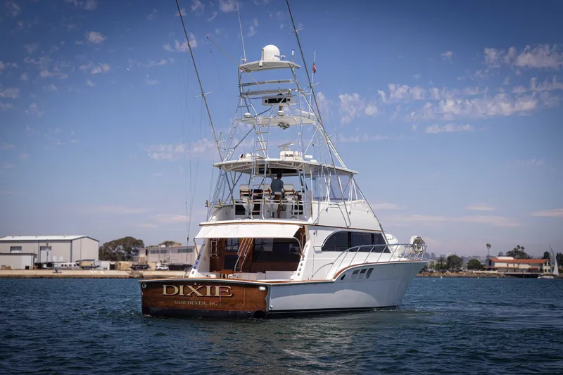 Slide: The Image of 1988 Donzi yacht "Dixie" on water, clear sky, marina background. - 2