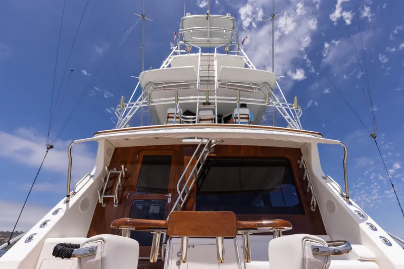 Slide: The Image of 1988 Donzi yacht with wooden accents and multiple decks under a clear blue sky. - 3
