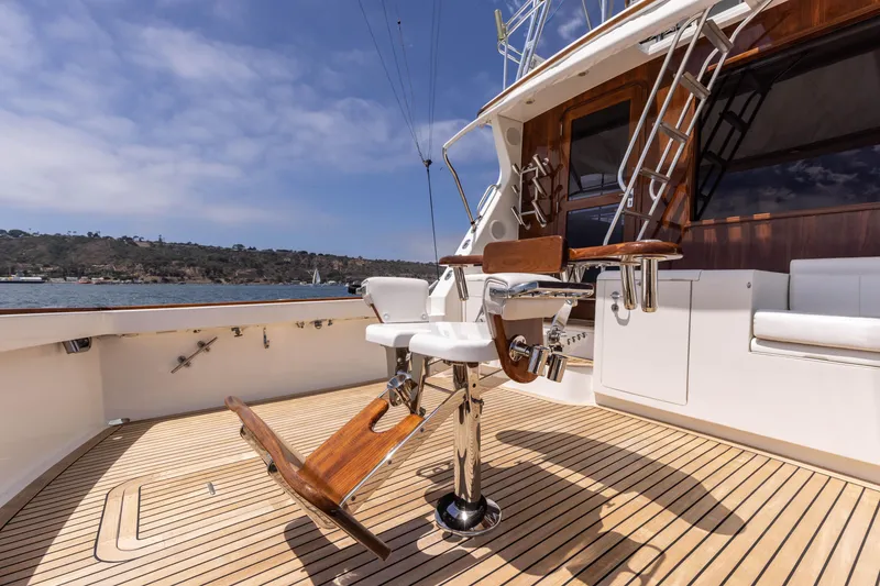 Slide: The Image of 1988 Donzi boat deck with fishing chair, wooden flooring, and scenic water view. - 4