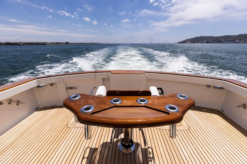 Slide: The Image of 1988 Donzi boat deck with wooden table, ocean view, and wake trail. - 5