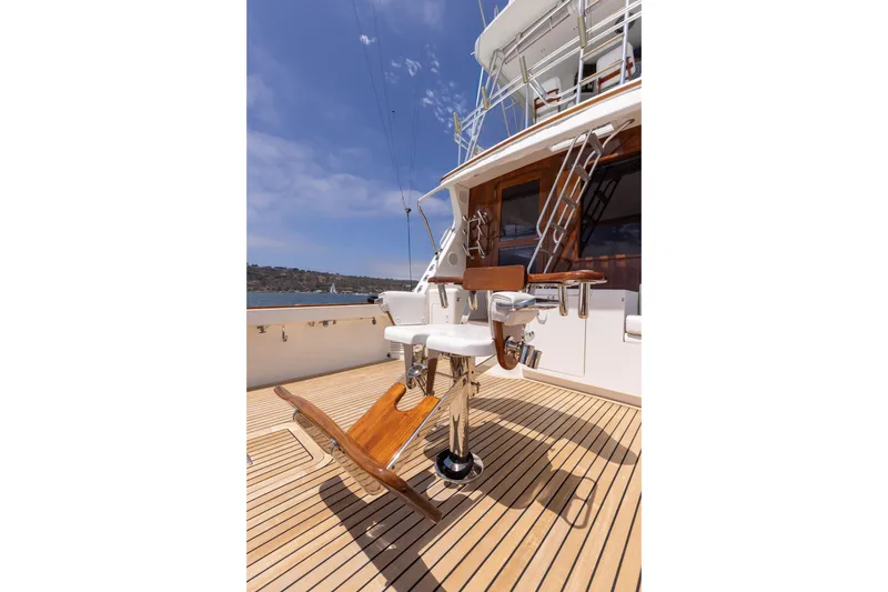 Slide: The Image of 1988 Donzi boat deck with fishing chair, wooden flooring, and clear blue sky. - 6