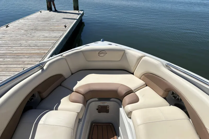 Slide: The Image of 2017 Crownline 275 SS boat interior with beige seating near a wooden dock. - 10