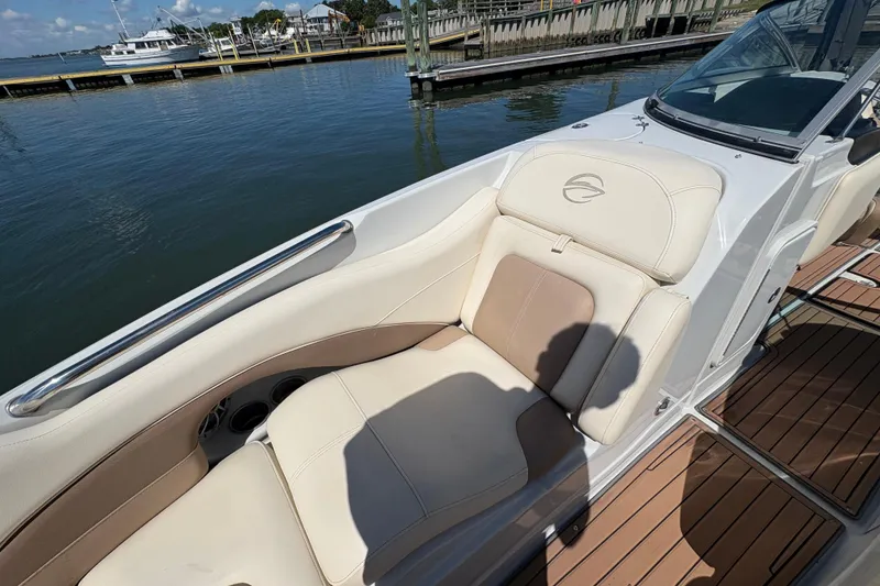 Slide: The Image of 2017 Crownline 275 SS boat with beige seating, docked by the water. - 12