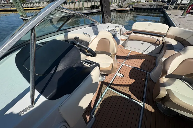 Slide: The Image of 2017 Crownline 275 SS boat interior with beige seating and wooden flooring. - 15