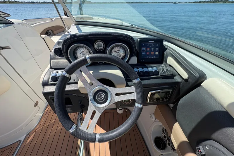 Slide: The Image of Steering wheel and dashboard of 2017 Crownline 275 SS boat, overlooking serene water. - 19