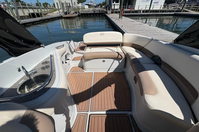 Slide: The Image of 2017 Crownline 275 SS boat interior with seating and sink, docked by the water. - 22