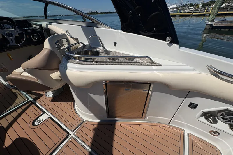 Slide: The Image of 2017 Crownline 275 SS boat interior with seating, sink, and wooden flooring. - 24