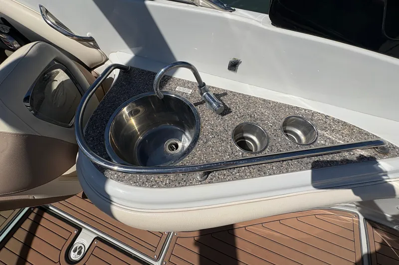 Slide: The Image of 2017 Crownline 275 SS boat sink with granite countertop and cup holders. - 25