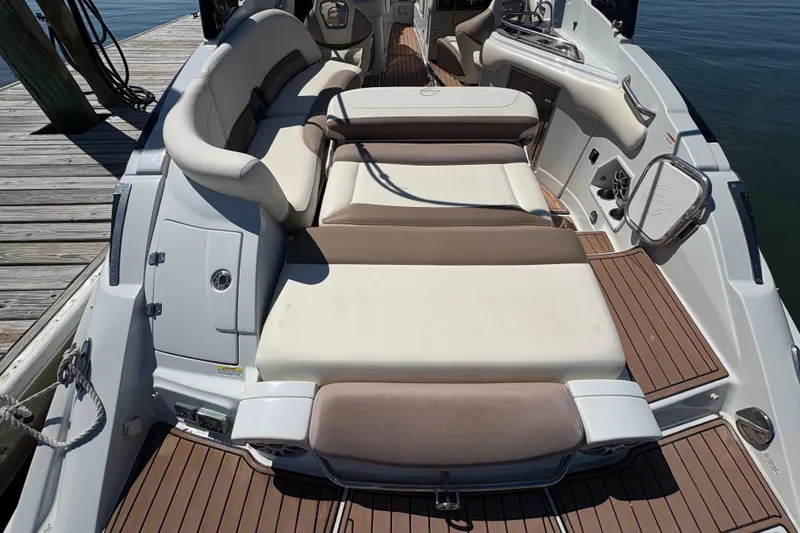 Slide: The Image of 2017 Crownline 275 SS boat interior with cushioned seating and wooden deck. - 29