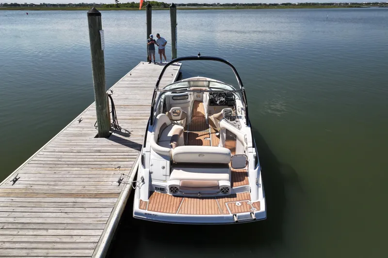Slide: The Image of 2017 Crownline 275 SS boat docked on calm water, featuring spacious seating and sleek design. - 5