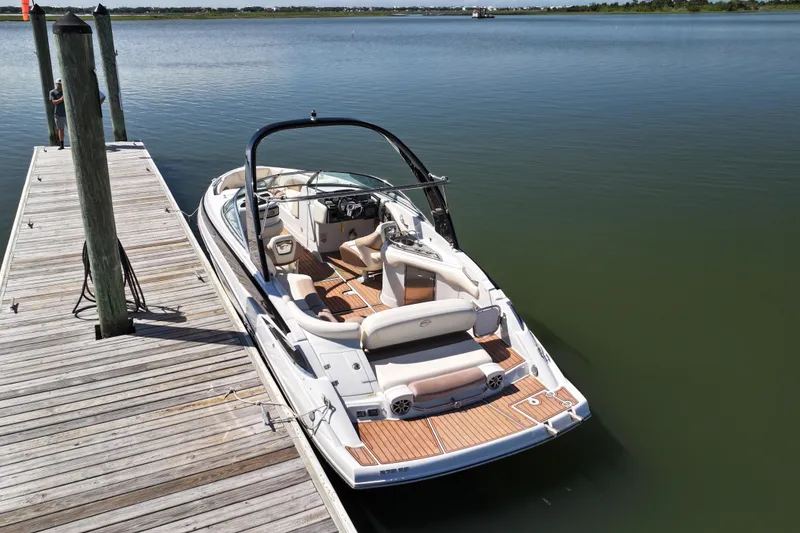 Slide: The Image of 2017 Crownline 275 SS boat docked on calm water, showcasing sleek design and spacious interior. - 6