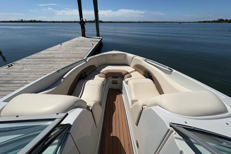 Slide: The Image of 2017 Crownline 275 SS boat with spacious seating, docked by a serene lake. - 8