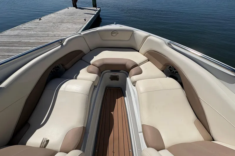 Slide: The Image of 2017 Crownline 275 SS boat interior with beige seating near a dock. - 9