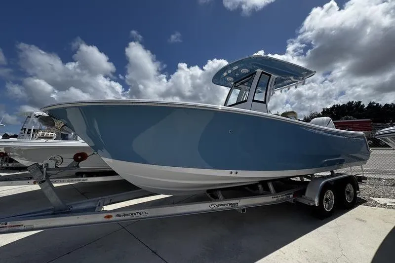 The Image of 2026 Sportsman Open 232 Center Console boat on trailer under cloudy sky. - 0