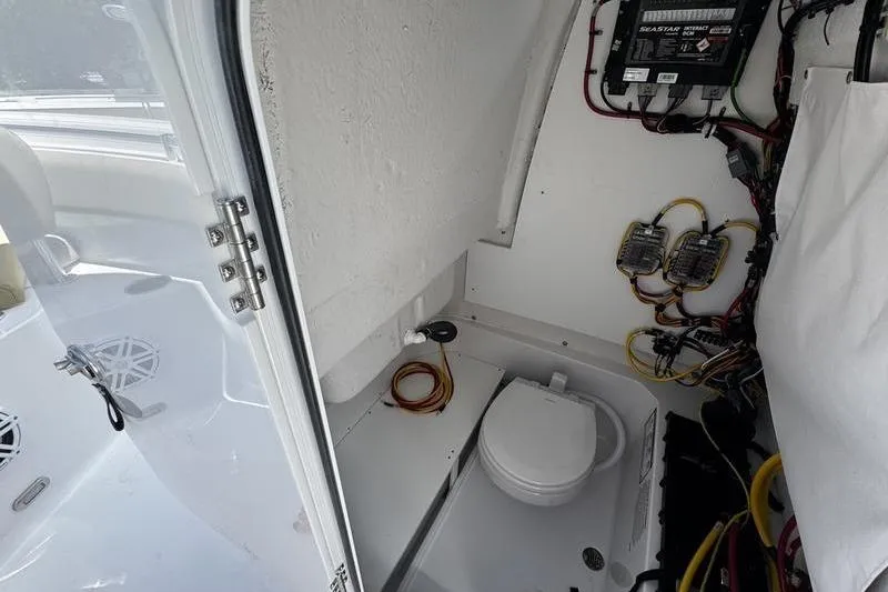 Slide: The Image of 2026 Sportsman Open 232 Center Console boat interior with toilet and wiring. - 12