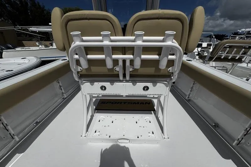 Slide: The Image of 2026 Sportsman Open 232 Center Console boat interior with rod holders and cushioned seating. - 20