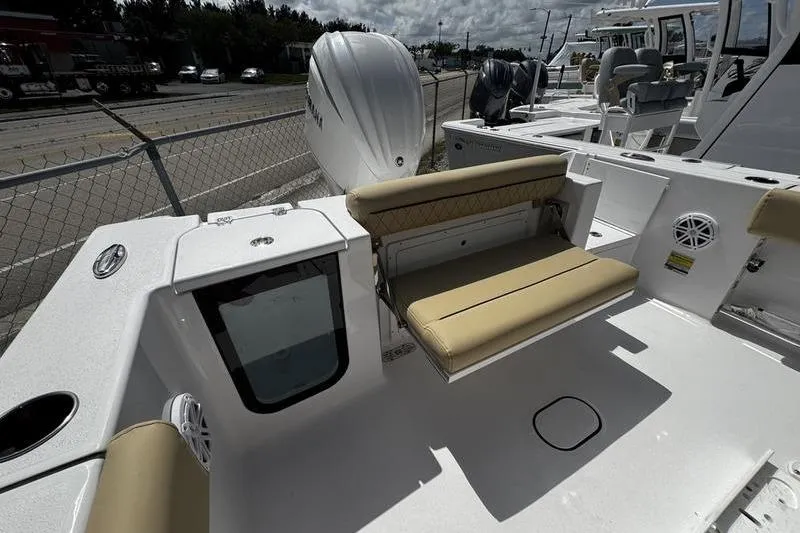 Slide: The Image of 2026 Sportsman Open 232 Center Console boat with beige seating and outboard motor. - 22