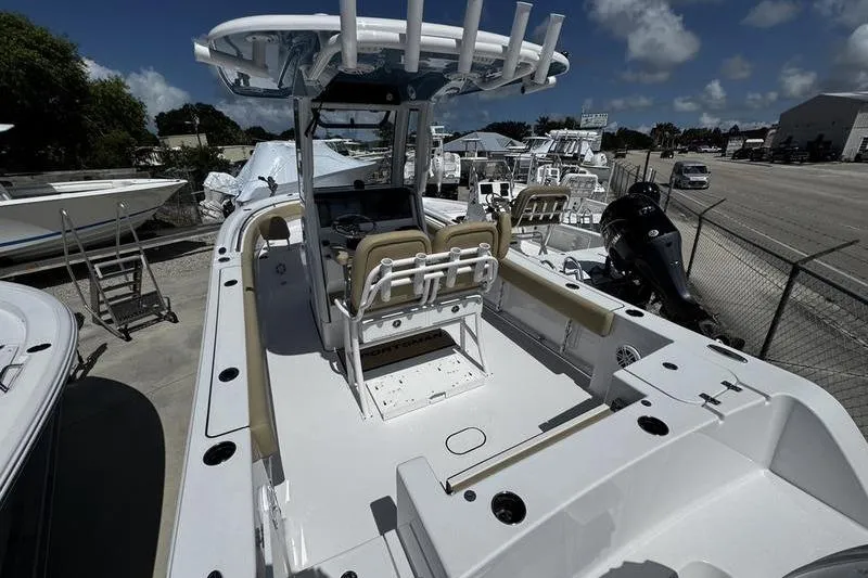 Slide: The Image of 2026 Sportsman Open 232 Center Console boat with seating and console, docked outdoors. - 24