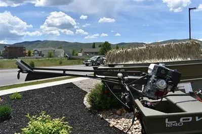 Slide: The Image of 2024 Lowe L1240 Jon boat with motor, parked outdoors under a clear blue sky. - 10