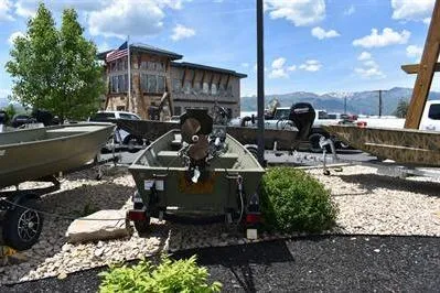 Slide: The Image of 2024 Lowe L1240 Jon boat displayed outdoors with scenic mountain backdrop. - 3
