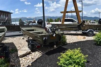 Slide: The Image of 2024 Lowe L1240 Jon boat displayed outdoors on a trailer, surrounded by landscaping. - 4