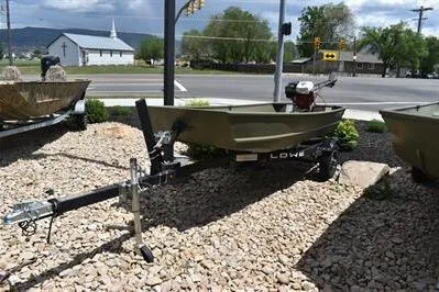 Slide: The Image of 2024 Lowe L1240 Jon boat on trailer, parked on gravel near road. - 5