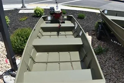 Slide: The Image of 2024 Lowe L1240 Jon boat displayed outdoors on gravel and mulch. - 7