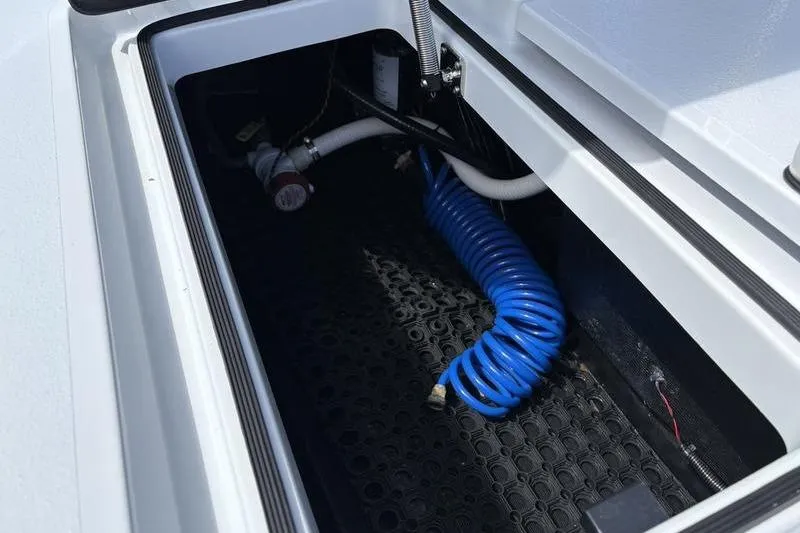 Slide: The Image of Storage compartment of 2022 East Cape Vantage boat with coiled blue hose. - 20