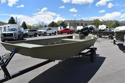 Slide: The Image of 2024 Lowe L1448 Jon boat on trailer in parking lot under blue sky. - 2