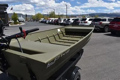 Slide: The Image of 2024 Lowe L1448 Jon boat on trailer in parking lot under blue sky. - 4