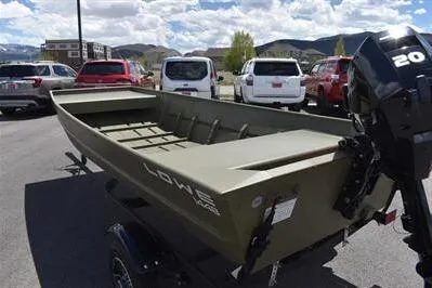 Slide: The Image of 2024 Lowe L1448 Jon boat with 20 HP motor, parked outdoors. - 5