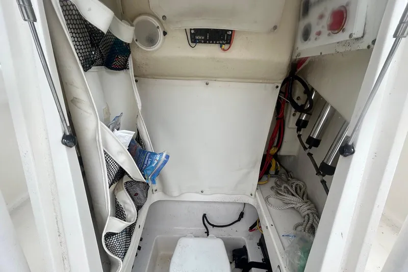 Slide: The Image of Interior storage compartment of a 2016 Wellcraft 242 Fisherman boat, featuring organized gear and equipment. - 11