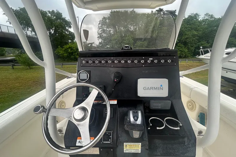 Slide: The Image of 2016 Wellcraft 242 Fisherman boat console with Garmin navigation system and steering wheel. - 2