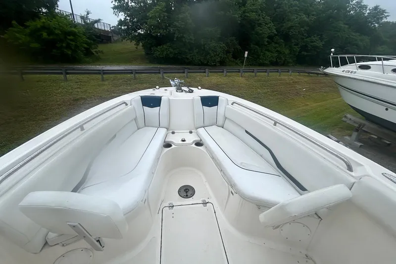 Slide: The Image of 2016 Wellcraft 242 Fisherman boat interior with white seating and lush greenery background. - 5