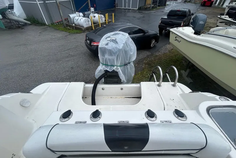 Slide: The Image of 2016 Wellcraft 242 Fisherman boat with covered outboard motor in a parking area. - 9